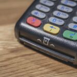 Un terminal de paiement noir avec clavier coloré sur bois
