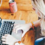 Femme blonde utilisant un ordinateur portable sur une table en bois