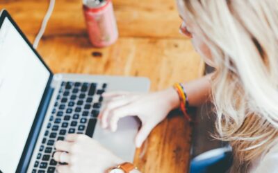 Femme blonde utilisant un ordinateur portable sur une table en bois