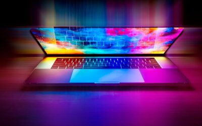 Un ordinateur portable ouvert avec écran lumineux et clavier sur fond sombre