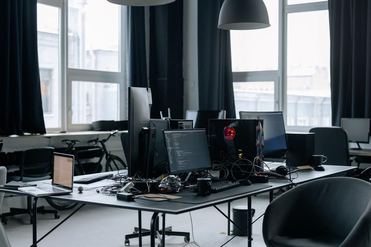 Un bureau moderne avec plusieurs écrans, chaises et lumière naturelle